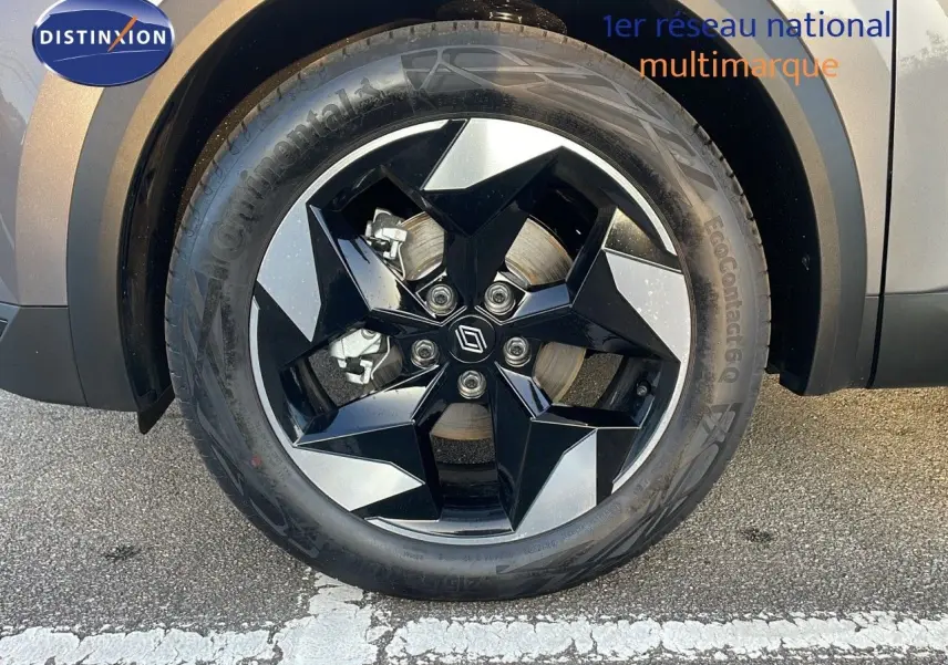 Gros plan sur la roue avant droite du Renault Captur gris Cassiopée Métal avec jante noire et argentée au design moderne.