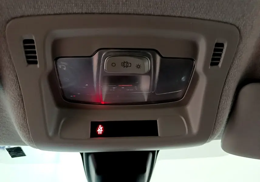 Vue intérieure en gros plan du plafonnier beige avec éclairage et témoin de ceinture allumé dans une Citroën C3 2022.