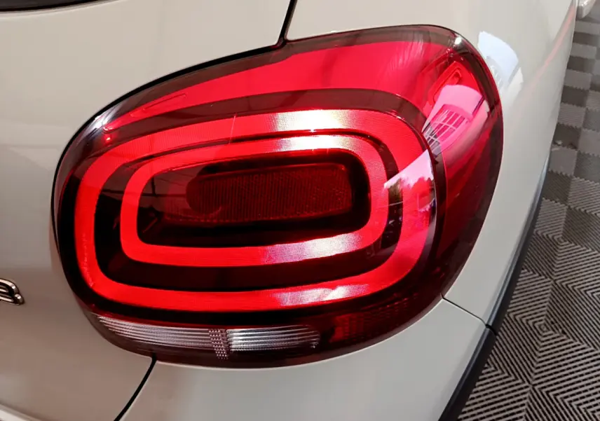 Gros plan sur le feu arrière droit rouge d’une Citroën C3 beige 2022, mettant en valeur son design lumineux distinctif.