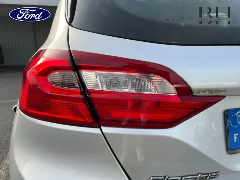 Gros plan sur le feu arrière droit rouge et blanc d'une Ford Fiesta gris lunaire, avec partie arrière du véhicule visible.