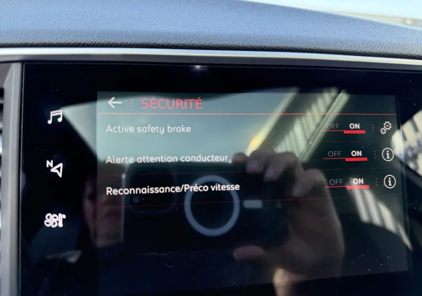 Écran tactile intérieur de la Peugeot 308 SW blanc nacré montrant le menu sécurité avec options activées.
