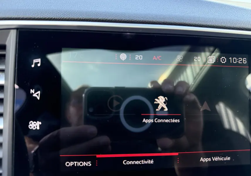Écran tactile central de la Peugeot 308 SW blanc nacré 2021 montrant le menu "Apps Connectées" avec icônes et réglages climatiques.