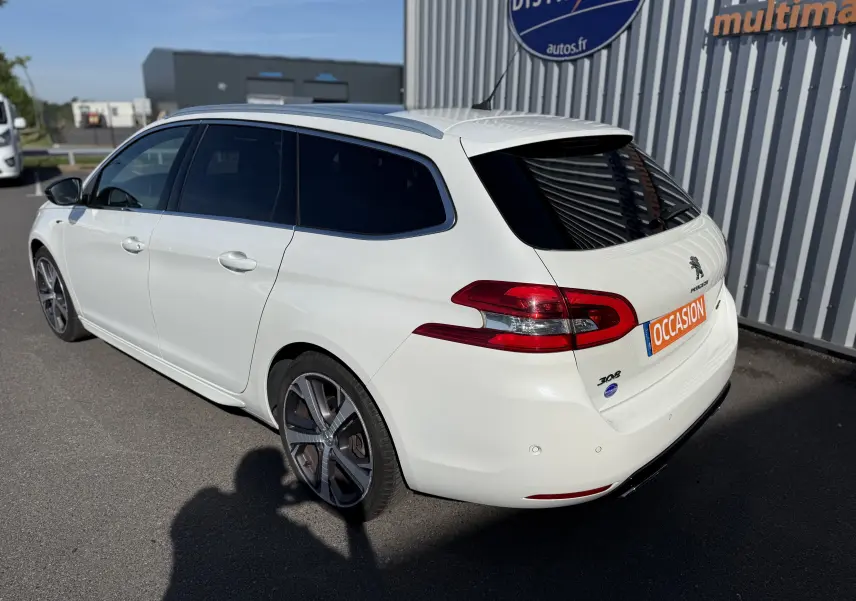 Peugeot 308 SW blanc nacré vue 3/4 arrière droit, break diesel avec vitres teintées et jantes alliage.