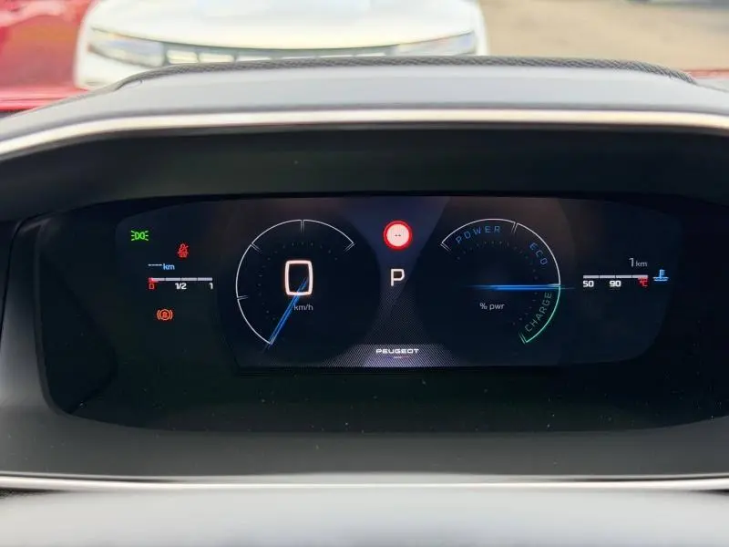 Tableau de bord numérique du Peugeot 2008 Hybrid 145ch GT, affichage vitesse et indicateurs énergie en vue frontale.