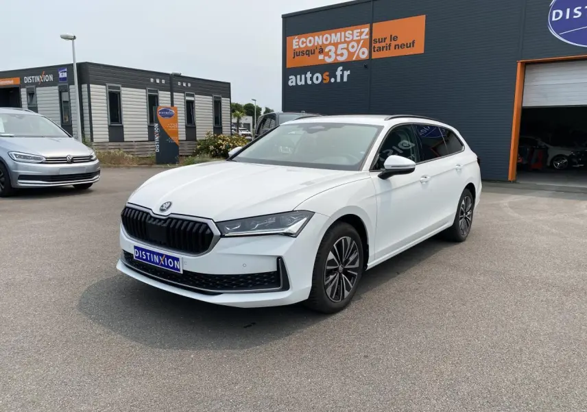 SKODA Superb Combi blanc pur en 3/4 avant droit, jantes alliage noires polies et vitres surteintées visibles.