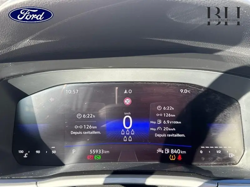 Tableau de bord numérique du Volkswagen Touran 2.0 TDI bleu, affichant la vitesse et informations de conduite.