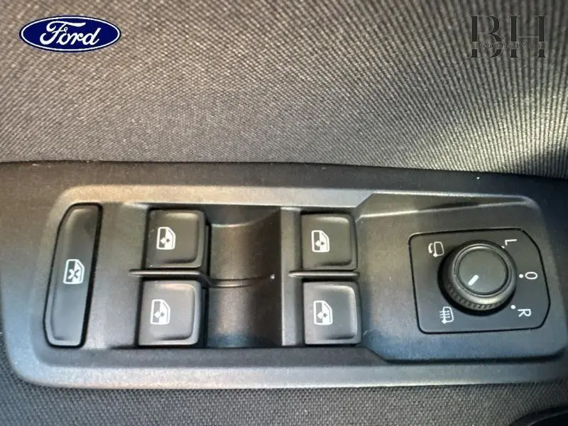 Panneau de commandes des vitres et rétroviseurs côté conducteur d'une Volkswagen Touran bleu Atlantique métallisé, intérieur noir.