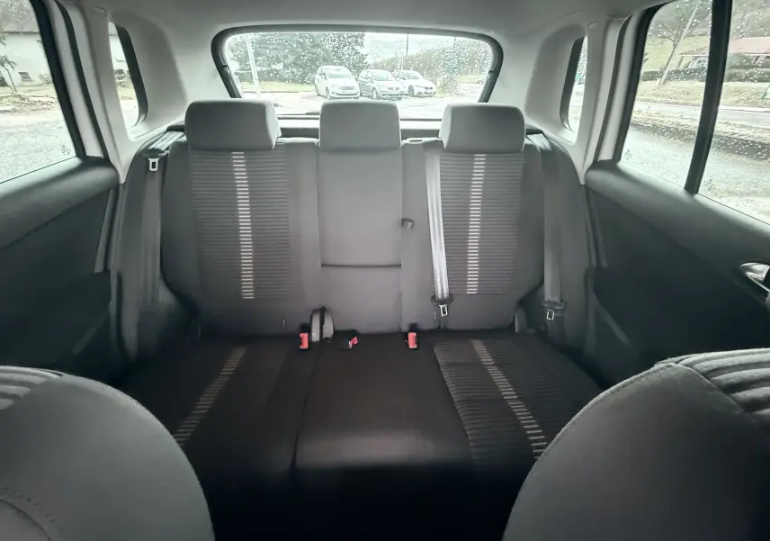 Vue intérieure arrière du Volkswagen Tiguan 2010 montrant la banquette arrière en tissu noir avec ceintures et appuie-têtes.