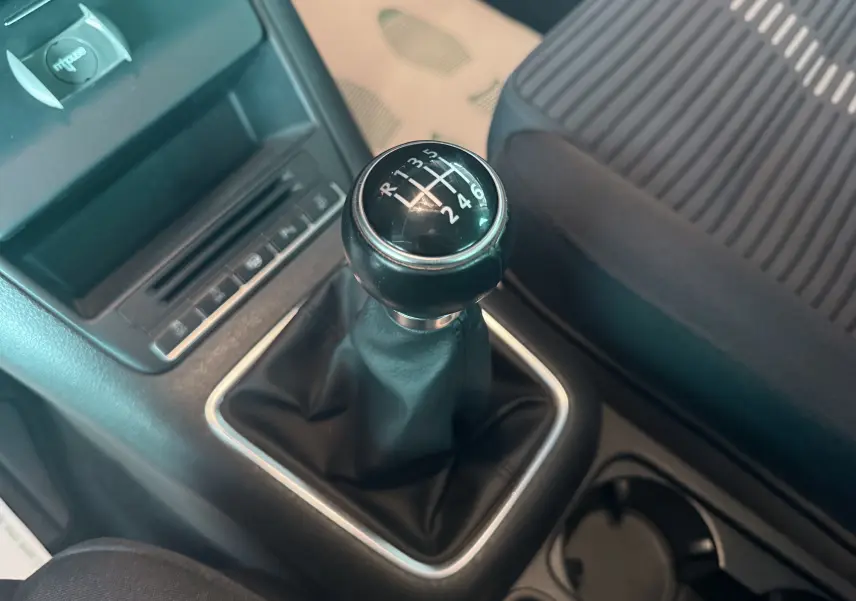 Gros plan sur le levier de vitesses manuel noir dans l’habitacle du Volkswagen Tiguan 2.0 TDI, siège tissu côté droit visible.