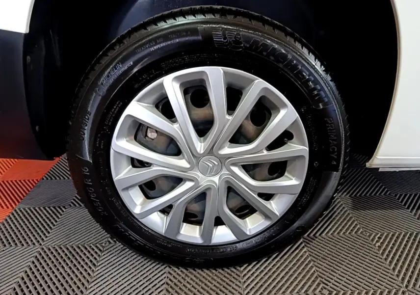 Gros plan sur la roue avant droite avec jante argentée et pneu Michelin du Citroën Berlingo blanc 2019.