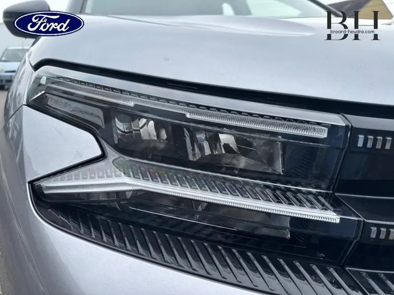 Gros plan sur le phare avant droit gris acier du Citroën C5 Aircross 2023 avec détails LED et calandre noire brillante.