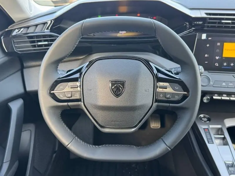 Vue frontale du volant multifonction noir de la Peugeot 308 2025 avec logo lion au centre et commandes intégrées.