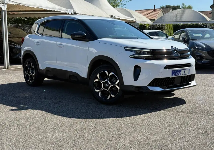 Citroën C5 Aircross blanc banquise en 3/4 avant droit avec jantes bi-ton et toit noir contrasté.