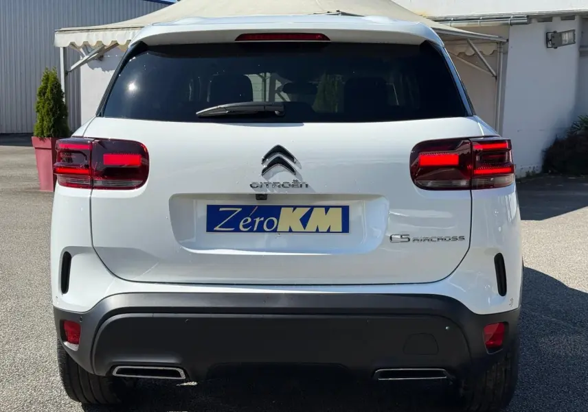 Vue arrière d'un Citroën C5 Aircross blanc banquise avec feux rouges et double sortie d'échappement intégrée.