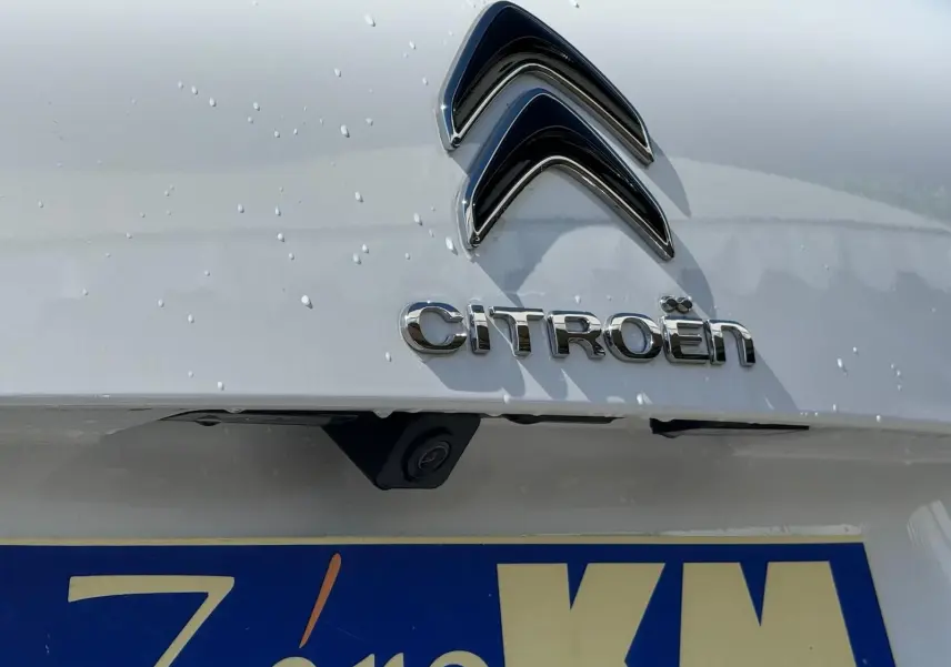 Gros plan sur l'arrière blanc banquise d'une Citroën C5 Aircross 2024, avec logo et caméra de recul visible.