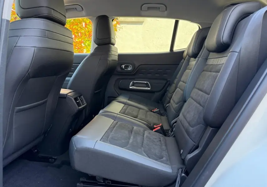 Vue latérale droite de l'habitacle arrière du Citroën C5 Aircross blanc banquise avec sièges en cuir noir et alcantara.