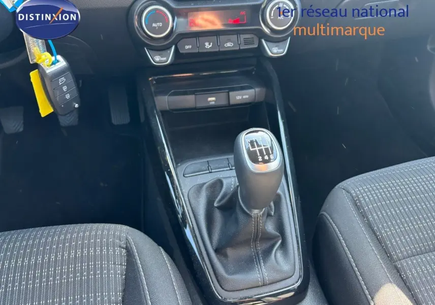 Le levier de vitesses manuel du Kia Stonic 2024 en vue rapprochée, avec console centrale et sièges en tissu noir.