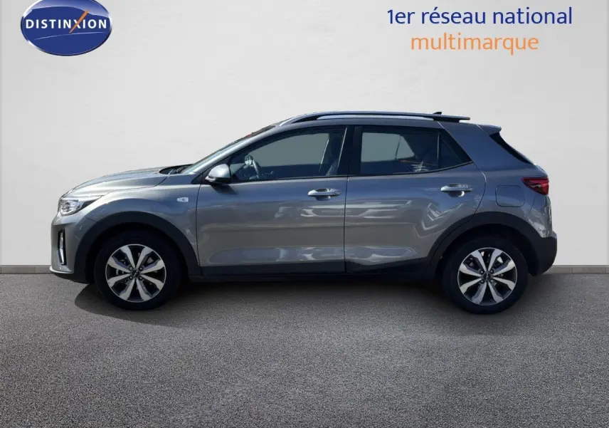 Profil côté gauche d'un Kia Stonic gris météore 2024, compact 5 portes avec jantes bi-ton et toit noir.