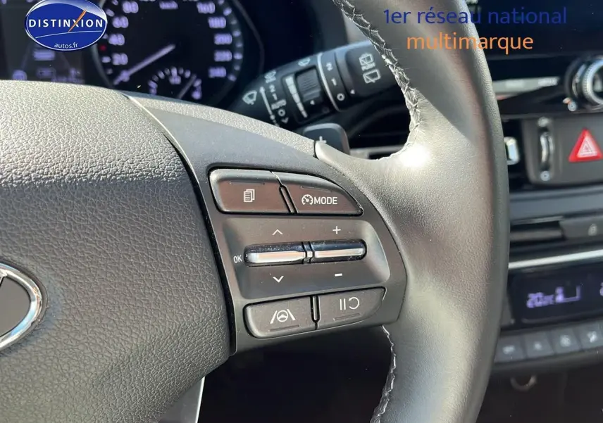 Gros plan sur le volant cuir multifonction de la Hyundai i30 gris argent avec commandes de régulateur et mode.