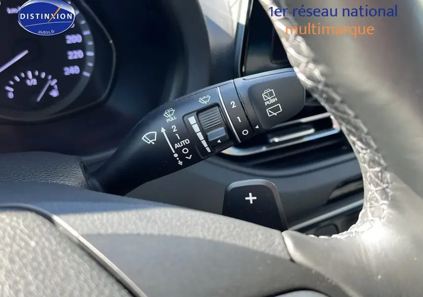 Gros plan sur la manette d'essuie-glace à gauche du volant cuir d'une Hyundai i30 gris argent 2024.