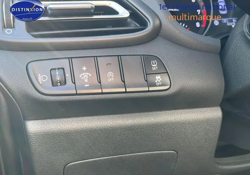 Tableau de bord côté gauche de la Hyundai i30 gris argent 2024 avec commandes d'éclairage et assistances visibles.