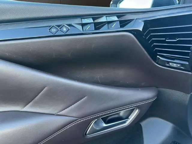 Gros plan sur la porte intérieure côté gauche en cuir noir avec commandes de verrouillage et design moderne du DS4 2022.