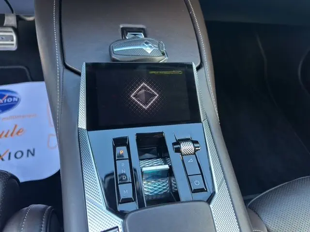 Gros plan sur la console centrale noire du DS4 2022, mettant en valeur le levier de vitesses automatique et l'écran tactile.