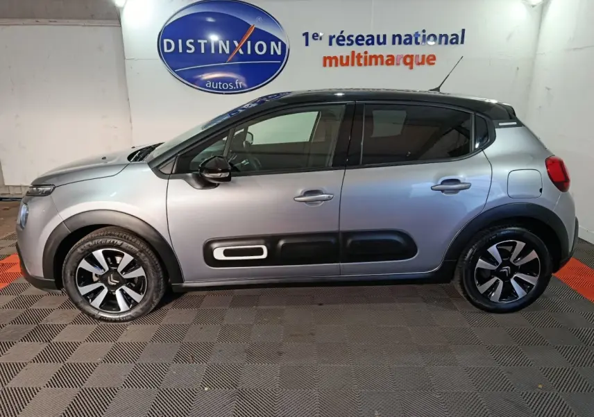 Vue latérale gauche d'une Citroën C3 gris foncé 2024 avec toit noir et protections latérales distinctives.