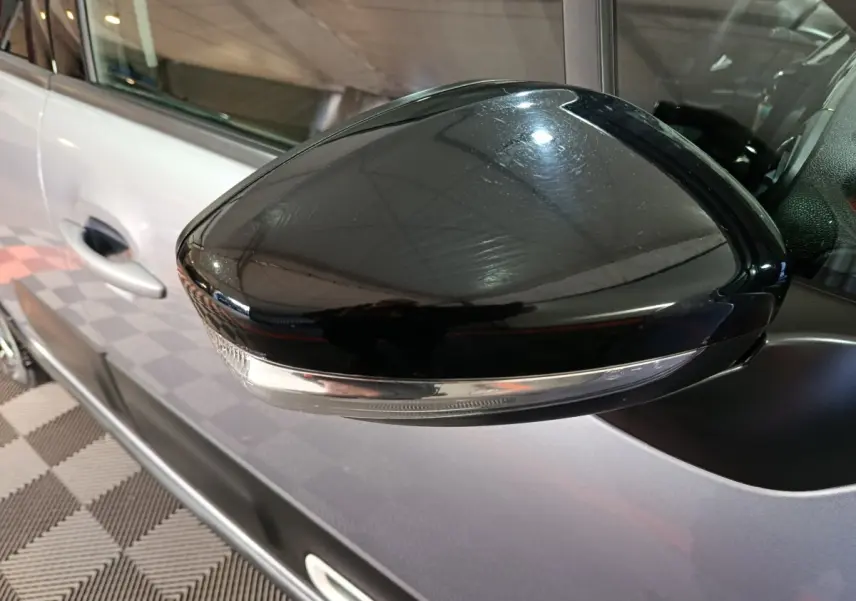Gros plan sur le rétroviseur droit noir brillant de la Citroën C3 gris foncé 2024, avec clignotant intégré.