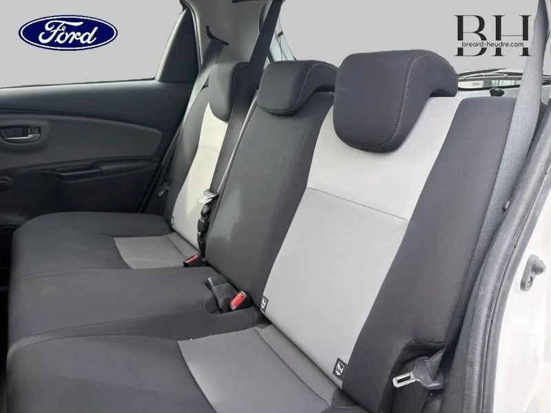 Vue intérieure des sièges arrière bicolores noir et gris d'une Toyota Yaris 116h France Business 5 portes, côté droit ouvert.