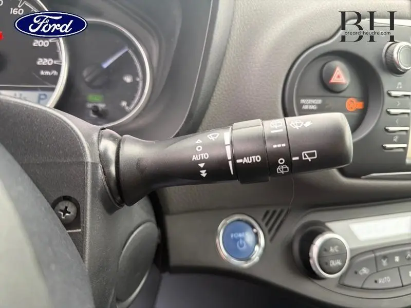 Levier de commande d’essuie-glace en gros plan à gauche du tableau de bord d’une Toyota Yaris blanche, intérieur noir.