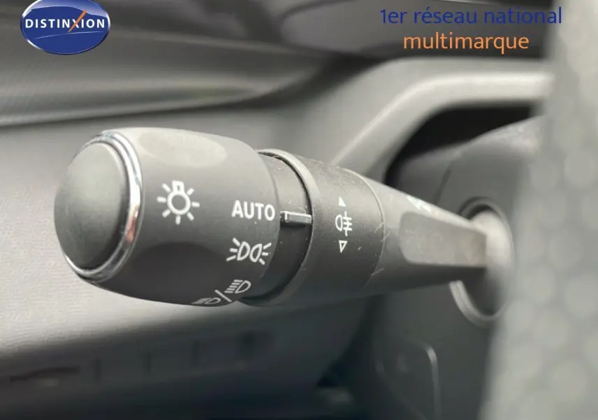 Gros plan sur la commande des feux automatique et antibrouillard dans l’habitacle du Peugeot 408 Hybrid 145ch noir métal 2024.