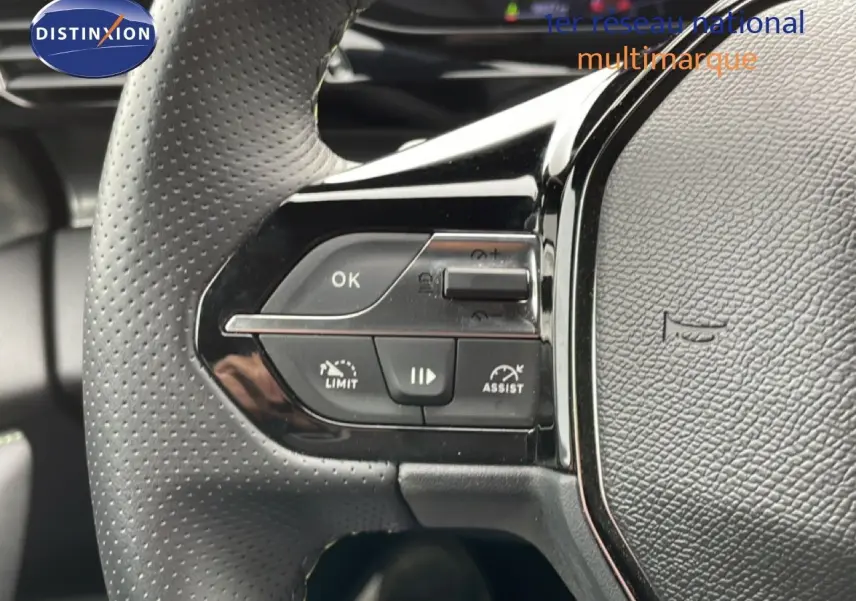 Gros plan sur les commandes gauche du volant noir perforé du Peugeot 408 Hybrid 145ch e-DCS6 GT 2024.