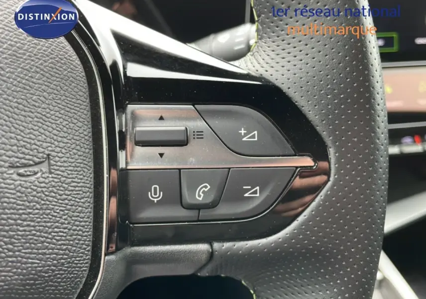Gros plan sur les commandes au volant en cuir perforé noir de la Peugeot 408 Hybrid 145ch GT 2024.