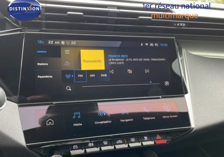 Vue rapprochée de l’écran tactile central du tableau de bord du Peugeot 408 noir métal, affichant la radio FM et les commandes multimédia.