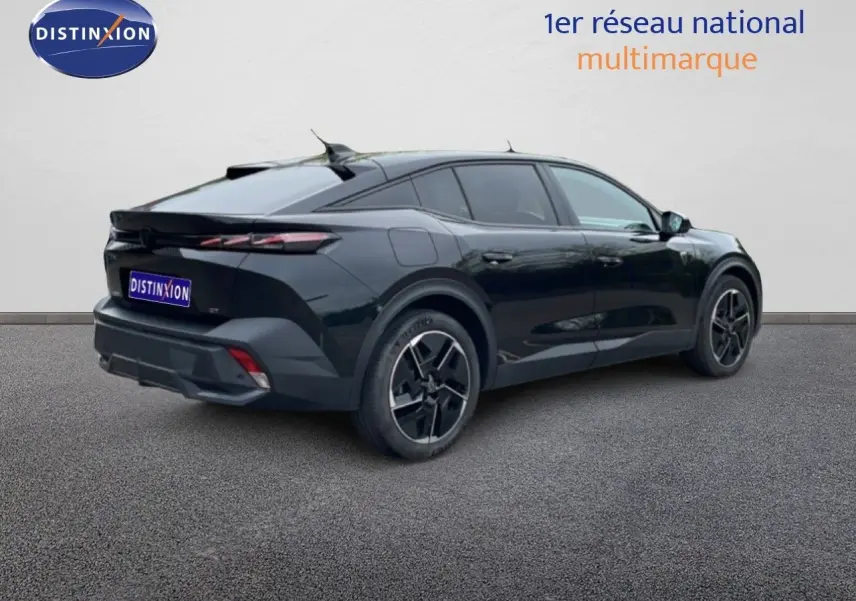 PEUGEOT 408 Hybrid noir métal en 3/4 arrière droit, soulignant ses lignes fluides et ses jantes noires distinctives.