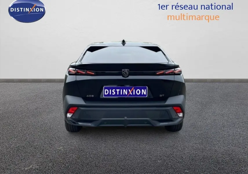 Vue arrière d'une Peugeot 408 Hybrid 145ch GT noire métal, avec feux LED fins et logo central distinctif.