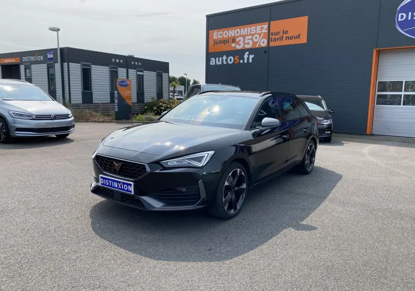 Vue 3/4 avant d'une CUPRA LEON ST 2024 noire Midnight avec jantes noires et calandre distinctive en concession.