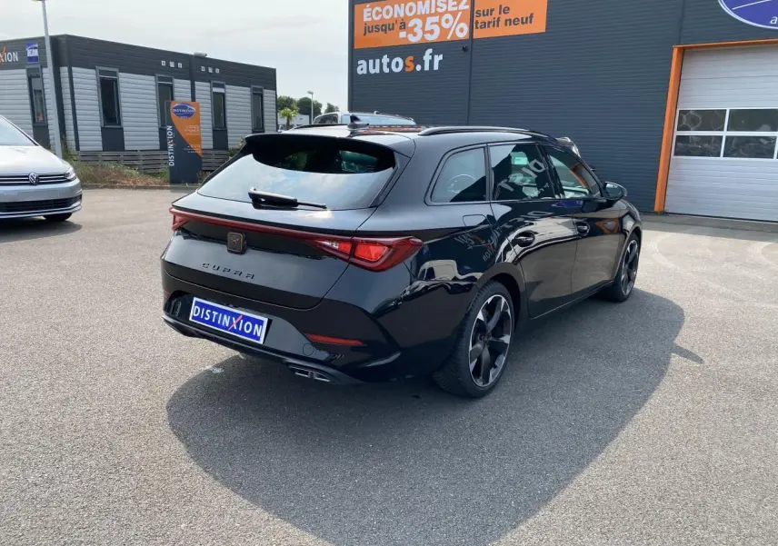 Vue 3/4 arrière droite d'une CUPRA LEON ST noire Midnight avec feux Tri-LED et jantes sport noires.