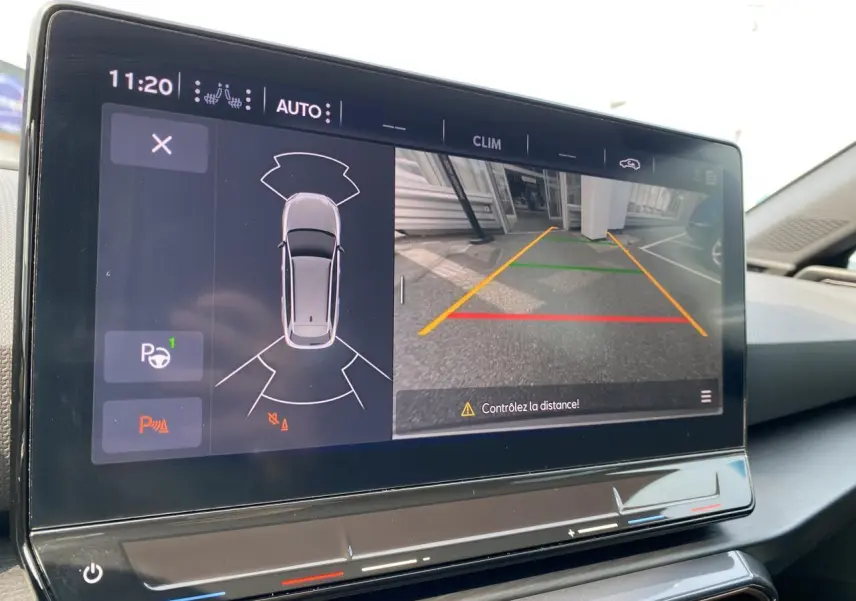 Écran tactile intérieur affichant la caméra de recul et l'aide au stationnement du CUPRA LEON ST noir Midnight 2024.