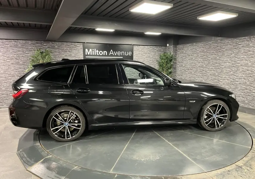 BMW Série 3 320e Touring noir vue de profil côté gauche avec jantes M Sport 19 pouces bicolores
