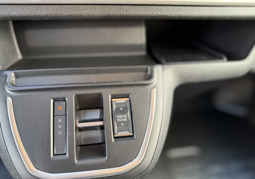 Gros plan sur la console centrale noire du Citroën Jumpy XL 2025, mettant en valeur la commande de boîte auto et le bouton Drive Mode.