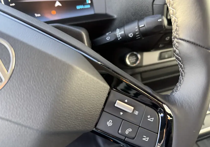 Gros plan sur le volant noir du Citroën Jumpy XL 2025, avec commandes audio et affichage numérique en arrière-plan.