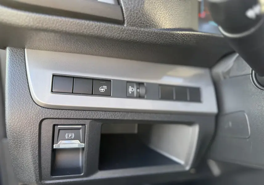 Détail du tableau de bord côté gauche du Citroën Jumpy Cabine Approfondie 2025 avec commandes de frein à main électrique et réglage phare.