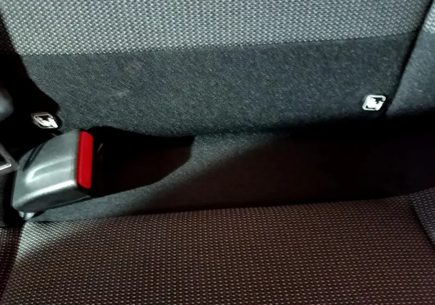 Gros plan sur la banquette arrière noire de la Citroën C3 avec boucle de ceinture de sécurité rouge visible.