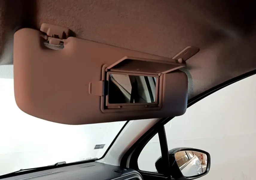 Vue intérieure du pare-soleil côté conducteur avec miroir de courtoisie ouvert dans une Citroën C3 blanche.