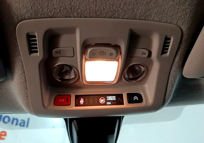 Vue intérieure du plafonnier avec éclairage allumé et boutons de commande dans une Citroën C3 blanche de 2020.