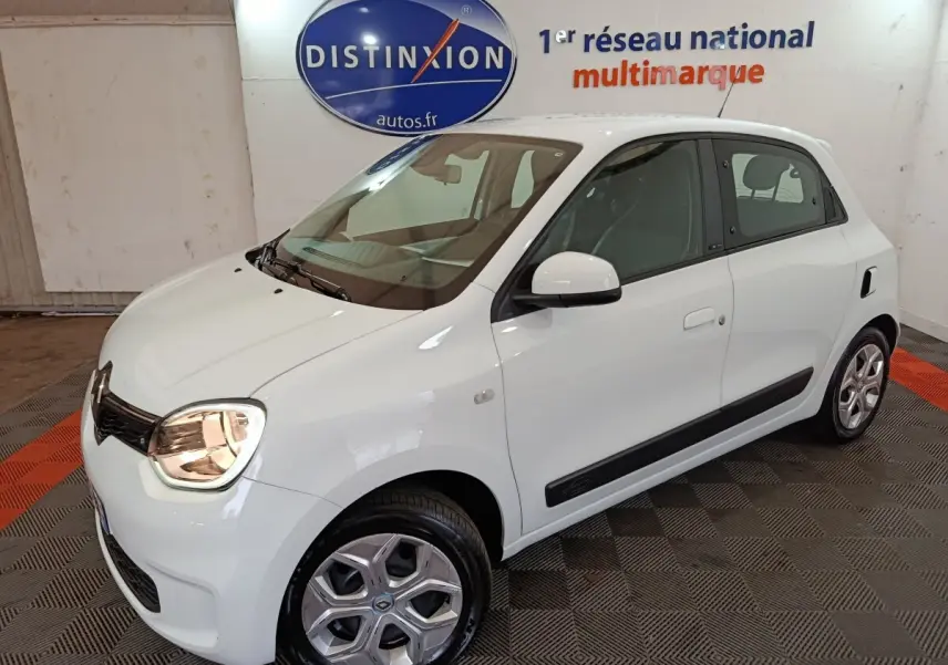 Vue 3/4 avant droite d'une Renault Twingo Zen blanche électrique, avec poignées et rétroviseurs assortis.