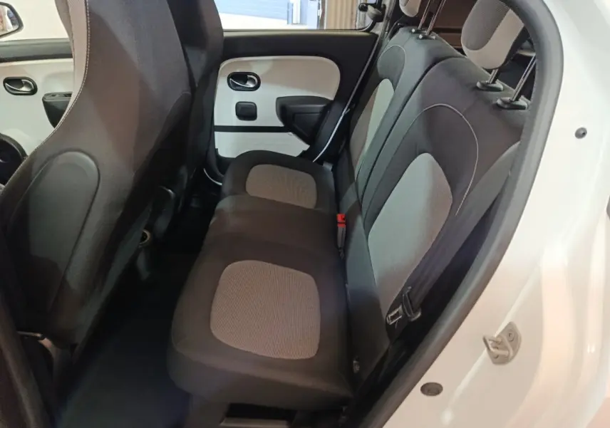 Vue intérieure arrière côté droit de la Renault Twingo Zen blanche, montrant la banquette 2 places avec sièges bicolores gris et noir.