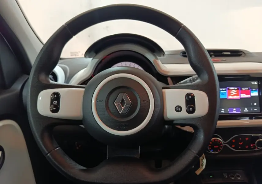 Vue centrée sur le volant noir et blanc de la Renault Twingo Zen 2021 avec tableau de bord et écran tactile visible.